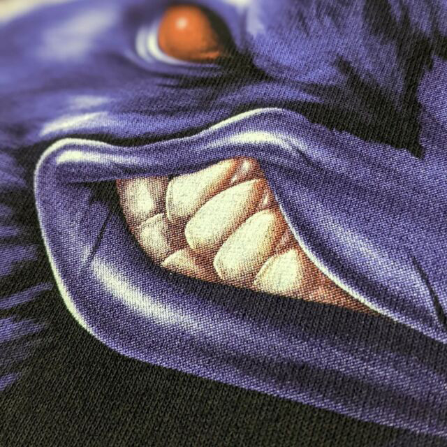 Detailed shot of a purple rave with red eyes digital print on a black tshirt.